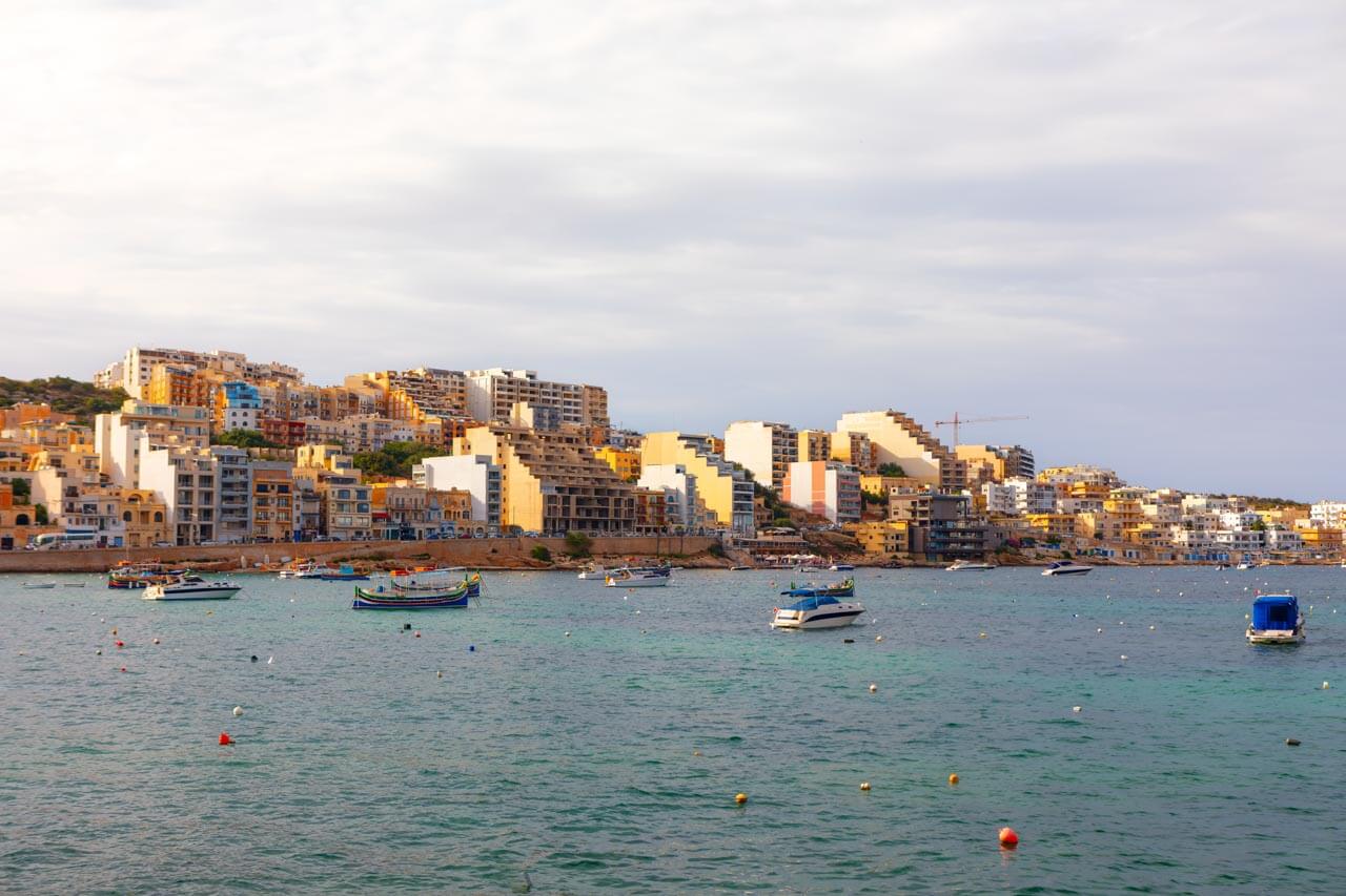 Hügelige Uferstadt mit Booten und Wohnblöcken, Englisch lernen vor Ort mit Freizeit.