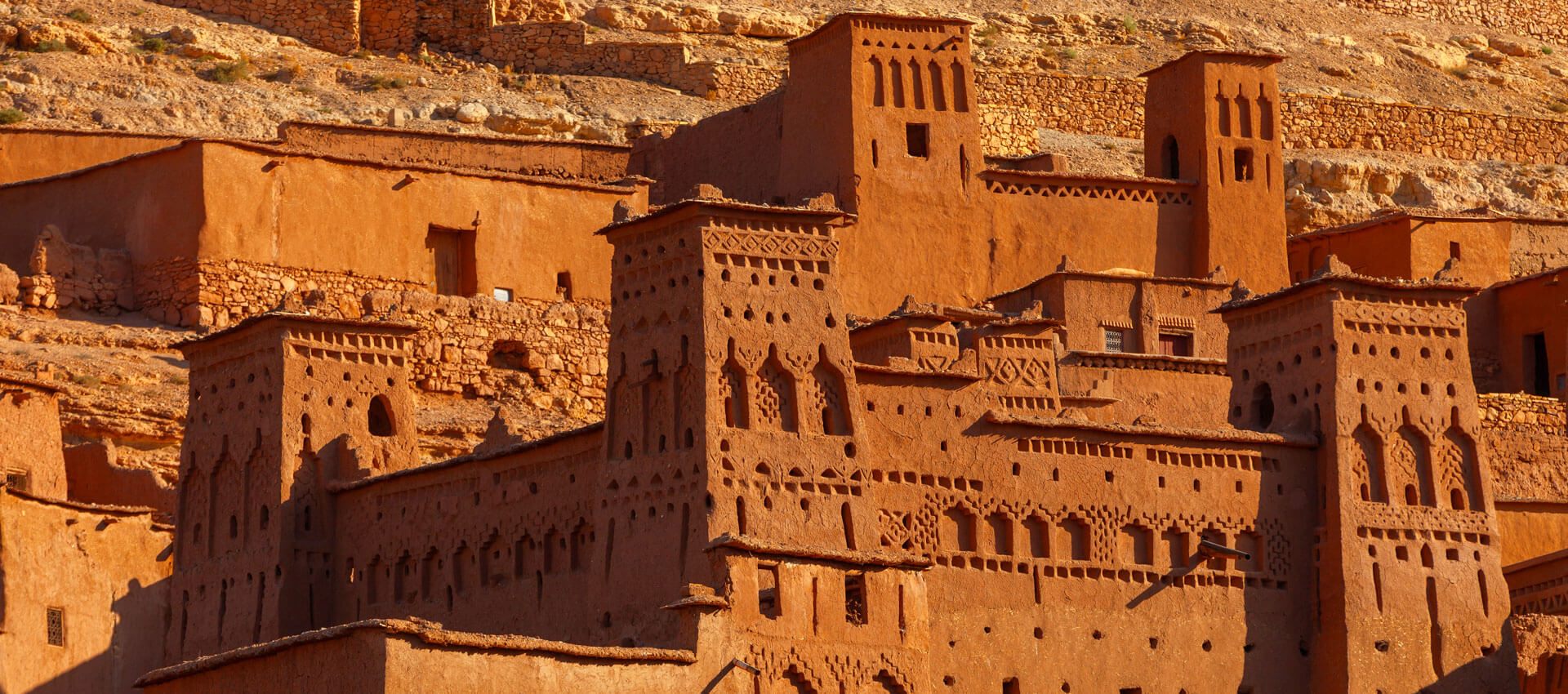 Lehmbauten einer Kasbah am Hang, Sprachreise Marokko mit Architektur entdecken.