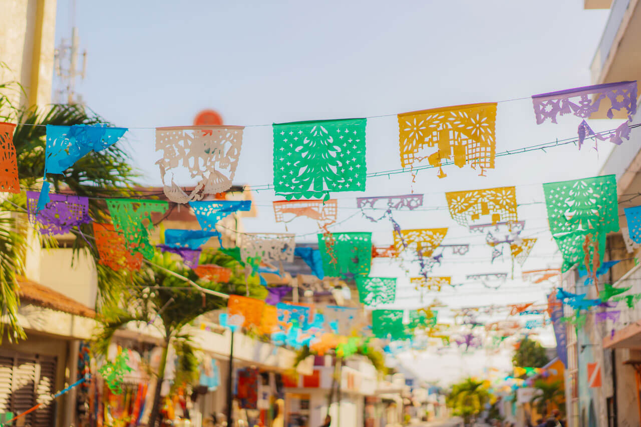 Bunte Wimpelketten über Straße in Playa del Carmen Sprachkurs Kultur erleben Grammatik üben
