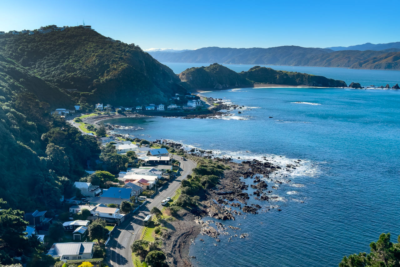 Klippenbucht mit Küstenstraße und Häusern, Konversation üben beim Spaziergang.