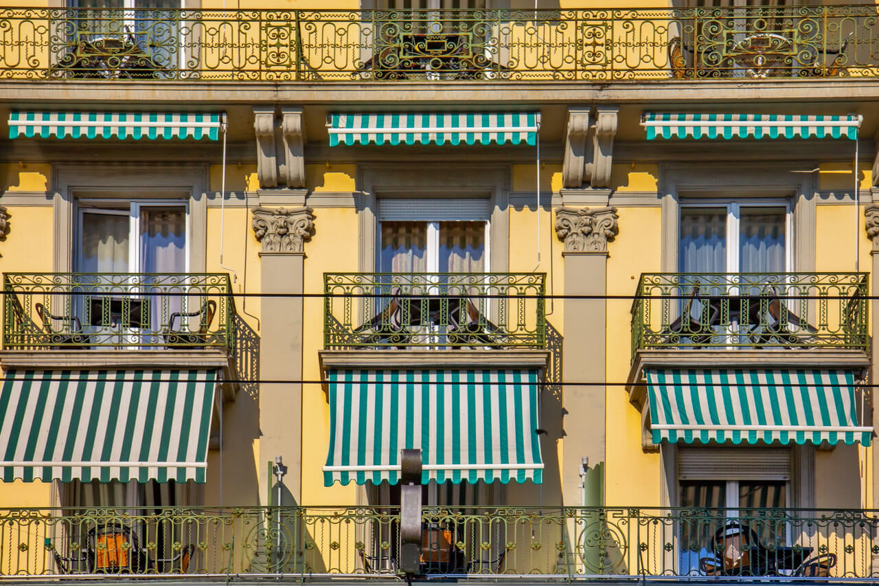 Fassade mit Balkonen und gestreiften Markisen, Grammatik üben beim Stadtspaziergang der Sprachreise