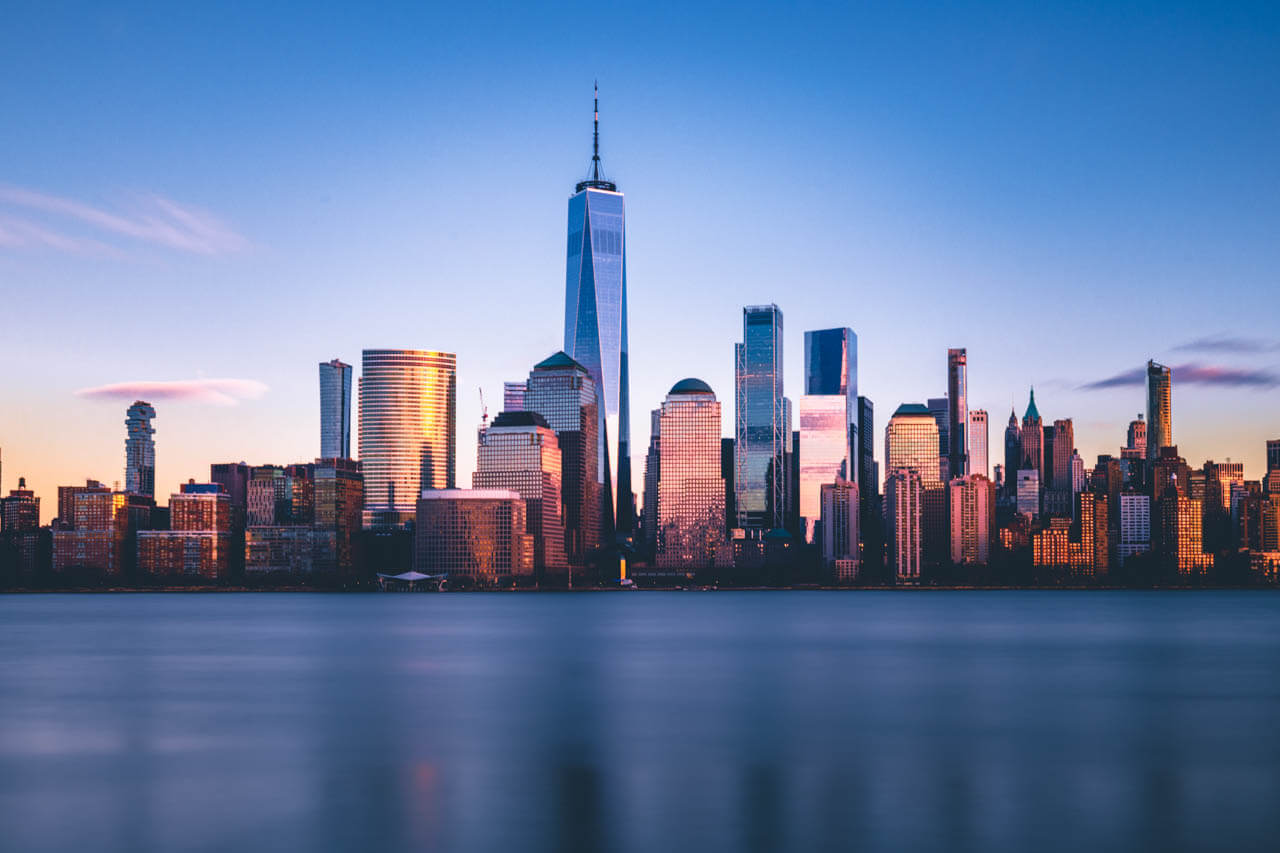 Skyline mit One World Trade Center im Abendlicht, Hörverstehen üben im Englischkurs.