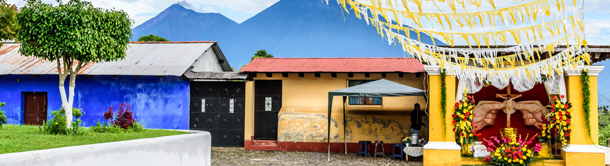 Bunte Häuserfassaden und kleine Kapelle vor Vulkanlandschaft in Antigua – Sprachreise nach Guatemala