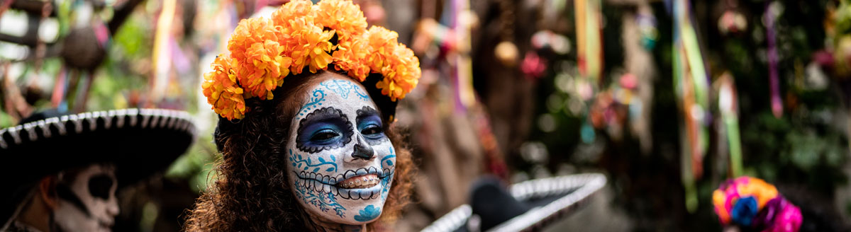 Traditionelles „Día de los Muertos“-Make-up mit Blumenkranz – kulturelles Erlebnis während der Sprachreise nach Mexiko