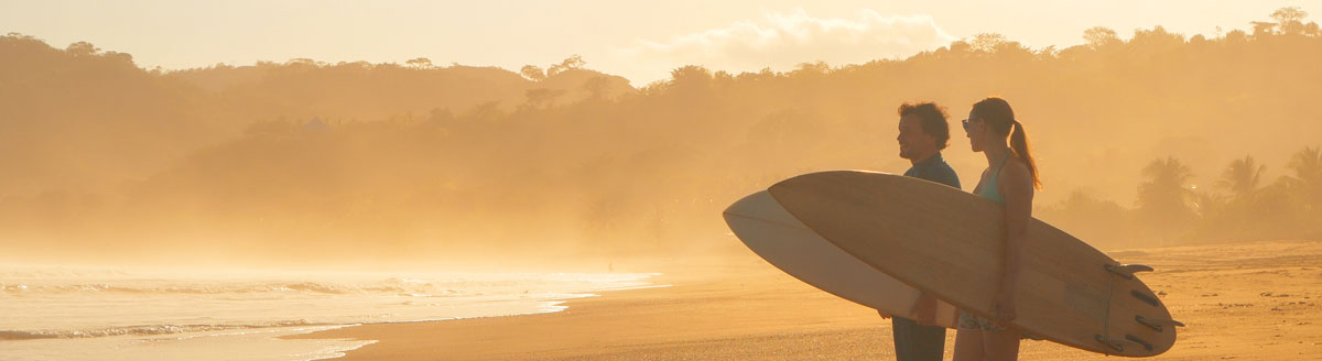 Surfer am Strand von Panama bei Sonnenuntergang – Freizeitaktivität während der Sprachreise