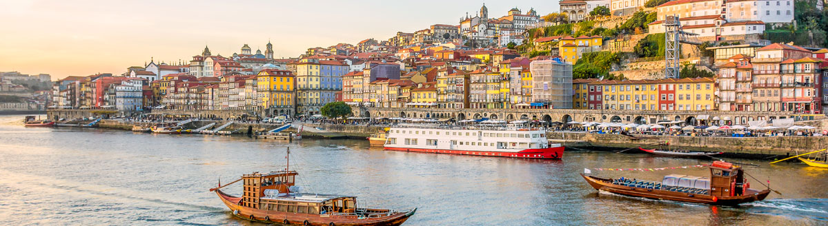 Blick auf die Altstadt von Porto mit bunten Häusern und Booten auf dem Douro – Sprachreise nach Portugal