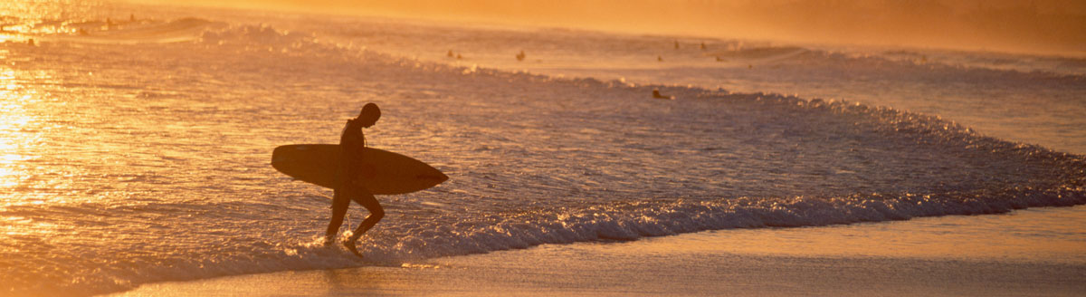 Surfer am Strand der Ostküste Australiens als atmosphärisches Motiv für Englisch-Sprachreisen nach Australien