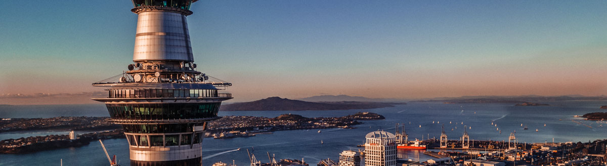 Auckland mit Sky Tower und Hafen bei Sonnenuntergang – beeindruckende Umgebung für Englisch-Sprachreisen nach Neuseeland