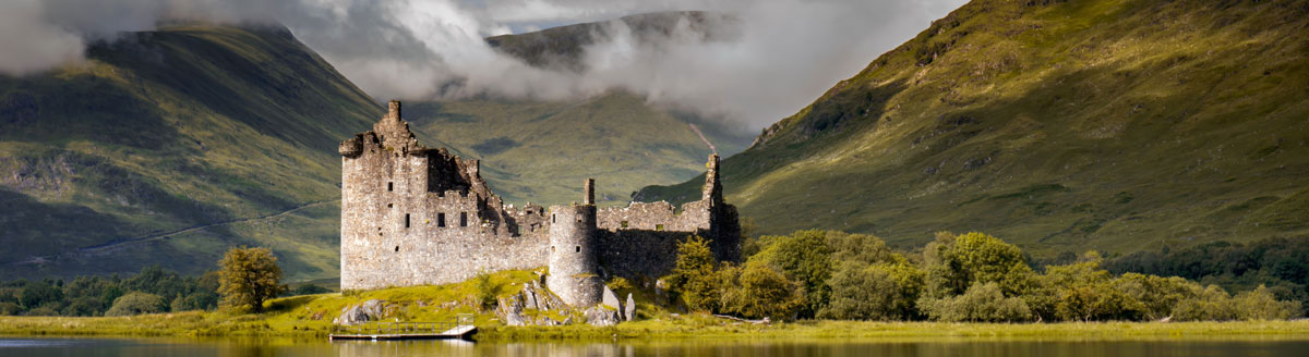 Historische Burgruine vor den Highlands als stimmungsvolles Motiv für Englisch-Sprachreisen nach Schottland