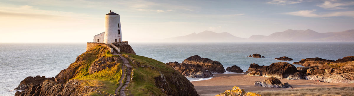 Küstenlandschaft mit Leuchtturm in Wales als inspirierendes Motiv für Englisch-Sprachreisen nach Großbritannien